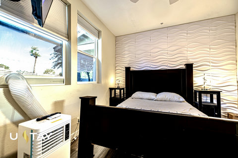 Bright bedroom with textured accent wall and large sunny windows