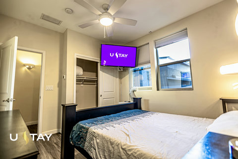 Bright modern bedroom with TV, natural light, and a cozy inviting feel