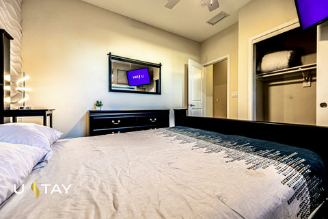 Modern, comfortable bedroom with TV, dresser, and convenient closet space