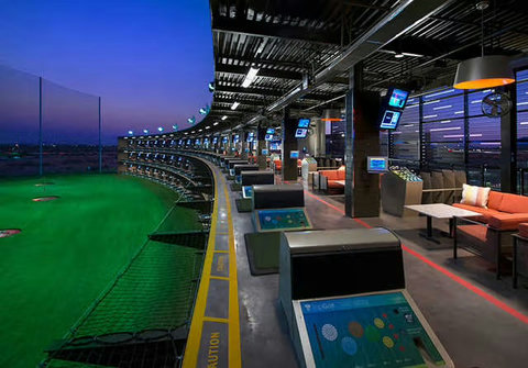 Modern golf entertainment venue with private bays and evening range views