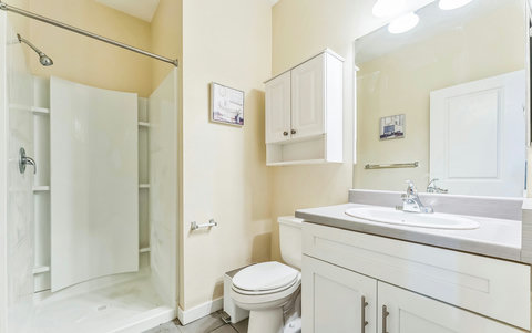 Bright, spotless bath with walk-in shower and ample storage