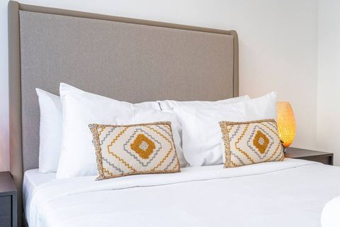 Imagine sinking into this plush bed after a long day, listening to the gentle sounds of the city outside.