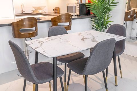 Elegant dining area featuring a marble table and plush chairs.