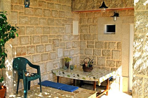 Entrance to the apartment, with big table in the shade, protected from the rain