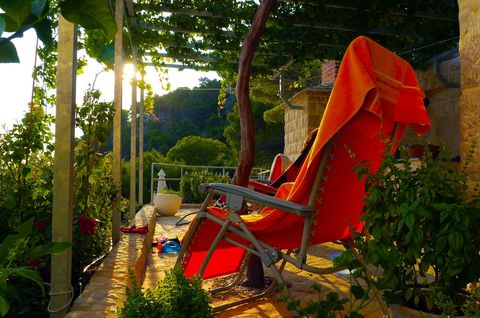Large terrace in the shade surrounded with lush vegetation and aromatic plants