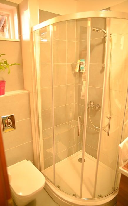 Bathroom with shower, floor-heating, laundry machine and small window.