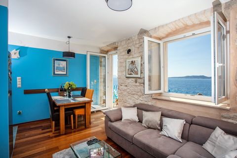 Bright and inviting living room with a stunning sea view, comfortable seating, and a smart TV for relaxing moments.
