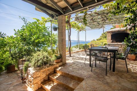 Beautiful garden with an outdoor dining area, framed by stunning views of the sparkling sea.