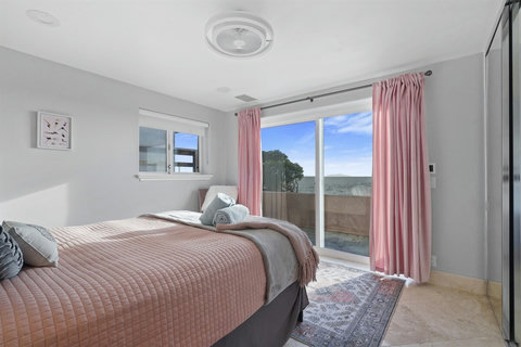 Queen Ground Floor Bedroom Perfect for family or friends, this inviting queen bedroom offers comfort and charm with its soft bedding and warm, coastal touches.