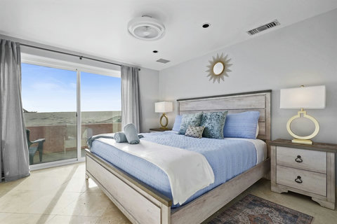 King Ground Floor Bedroom A tranquil retreat awaits on the ground floor. Rest peacefully in the king bedroom, complete with crisp linens, ocean-inspired décor, and a cozy ambiance.