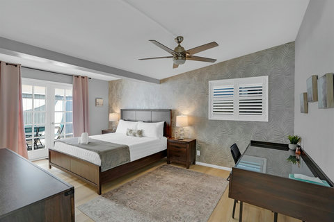 Primary king suite with an ensuite bathroom, patio access, and a desk—great for remote work or writing that beachside novel.