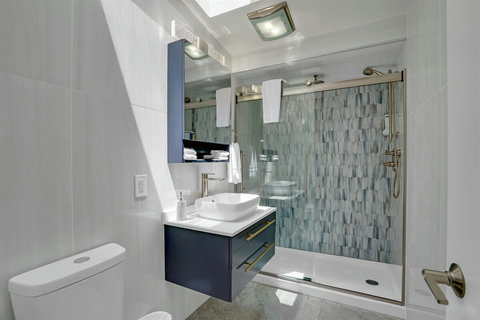 Main hallway bathroom with a sleek tiled shower—easy access for guests staying in any room.