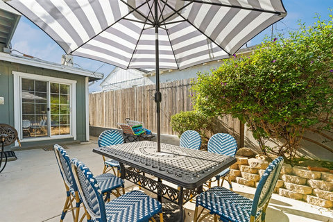 Unwind in the spacious backyard with a BBQ grill, cozy fire pit, and outdoor dining—perfect for relaxing evenings after a day at the beach.
