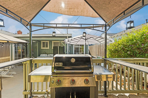 Unwind in the spacious backyard with a BBQ grill, cozy fire pit, and outdoor dining—perfect for relaxing evenings after a day at the beach.