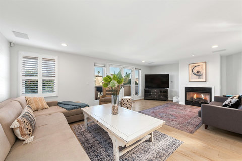 Spacious living room with two couches, a smart TV, and a cozy fireplace – perfect for relaxing after a day at the beach