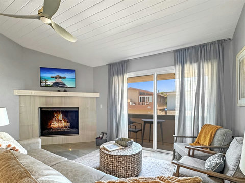 Gas fireplace in living room with balcony with ocean view