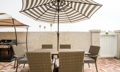 The secure front patio that has a grill and outdoor dining. 