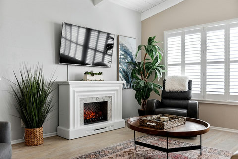Living Room Bliss: Sink into the Soft Leather Sofa, Stay Warm with the Electric Fireplace, and Take in the Beachfront Beauty.