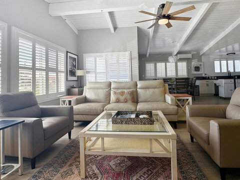 The Perfect Coastal Retreat: Unwind on the Leather Sofa, Embrace the Electric Fireplace's Warmth, and Get Lost in the Beach Views."