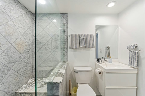 Ensuite Bathroom with Walk-in Shower Pamper yourself in the spacious ensuite bathroom with a modern walk-in shower, fresh hotel-style towels, and complimentary toiletries for a spa-like experience.
