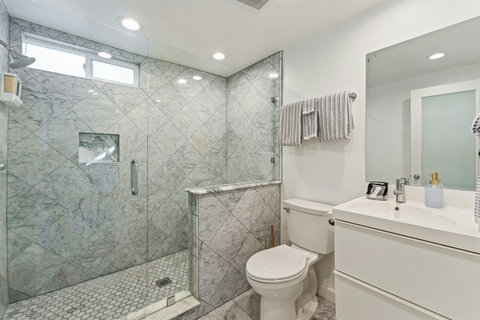 Ensuite Bathroom with Walk-in Shower Pamper yourself in the spacious ensuite bathroom with a modern walk-in shower, fresh hotel-style towels, and complimentary toiletries for a spa-like experience.