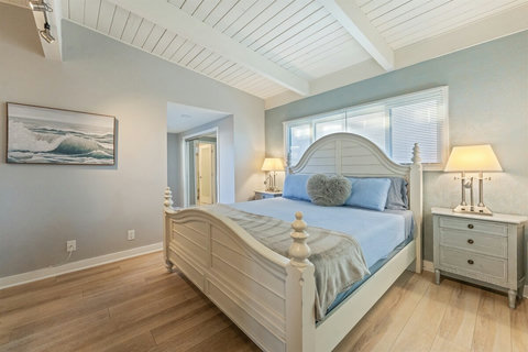 Primary King Suite Retreat to the luxurious primary suite featuring a plush king-sized bed, Smart TV, and balcony access to enjoy calming water views.