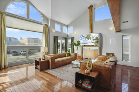 Natural light floods through floor-to-ceiling windows onto beautiful hardwood floors.
