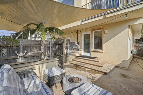 Unwind by the fire pit on your fenced-in front patio with comfy lounge seating—ideal for cool beach nights.