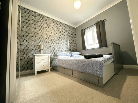 Second bedroom featuring extendable bed, bedside table, ample wardrobe space.