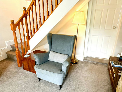 Living room, two-seater sofa, armchair, fire place, TV.