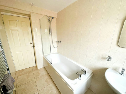 Bathroom with bath, shower, sink, WC, and heated radiator.