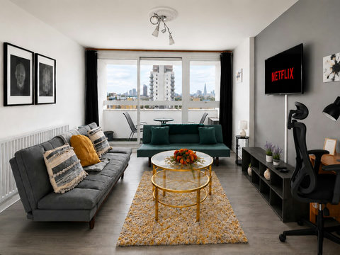 Bright living room with city views, private balcony, Smart TV, dedicated workspace and two sofa beds for additional guests.