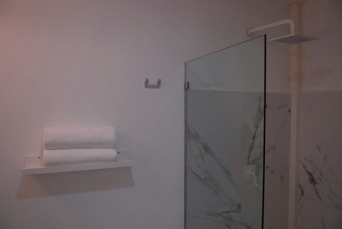 Toallas 100% algodón y regadera con cristal templado y calentador de paso.