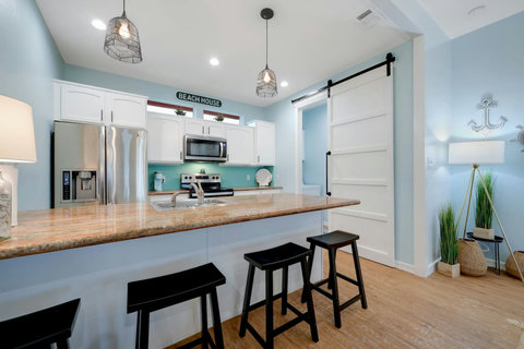 White kitchen with a long granite bar and bar stools