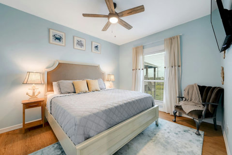 King bedroom with soft lighting and a cozy reading chair