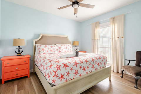 King bedroom with bright coral accents