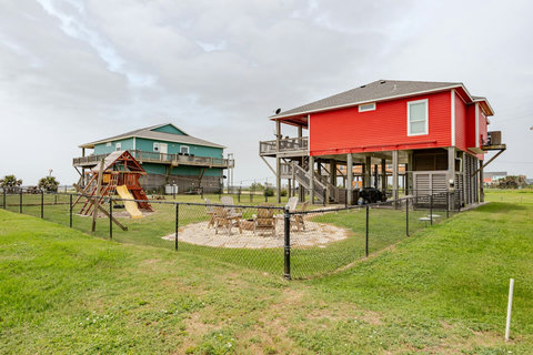 Fenced yard with a fire pit and playscape