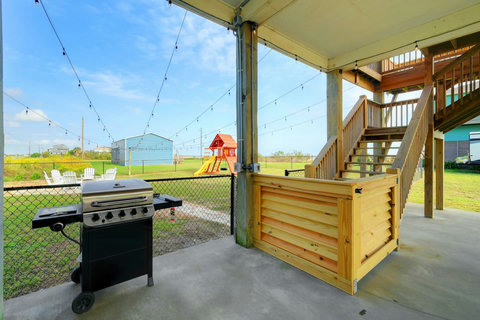 Gas grill by the stairs, with the playscape in view
