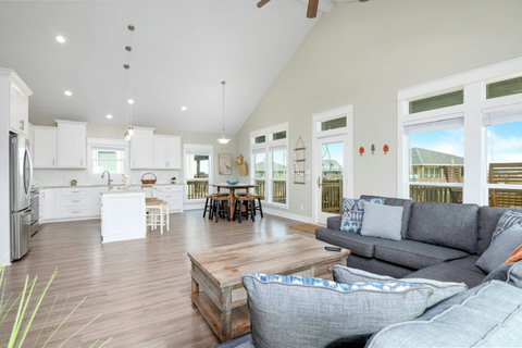 Open living room with vaulted ceilings, flowing into the kitchen