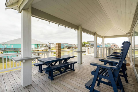 Covered deck with picnic tables and tall deck chairs