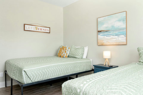 Two queen beds with coastal art