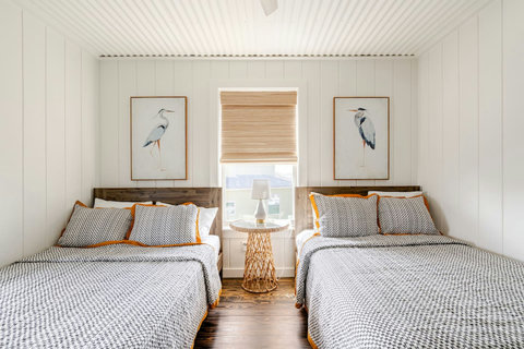 Bedroom with two full beds and heron art