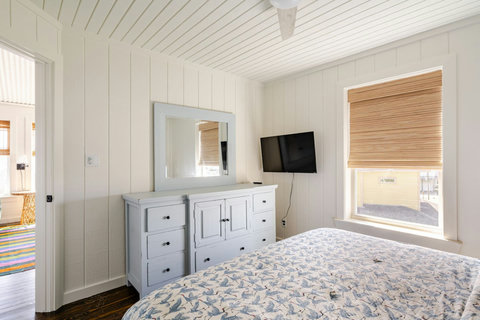 King bedroom with a dresser and TV