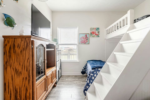 Bunk room with a TV and dresser