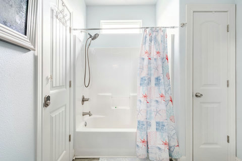 Clean, bright bath with a tub and shower