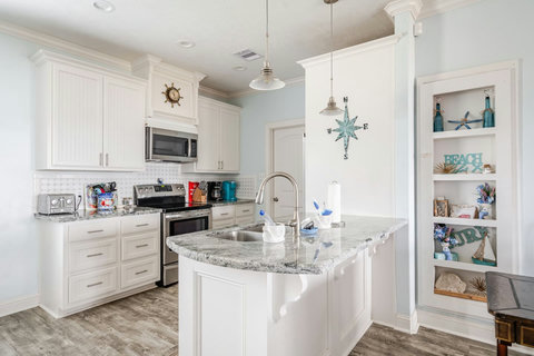 Bright white kitchen with granite counters and a big island