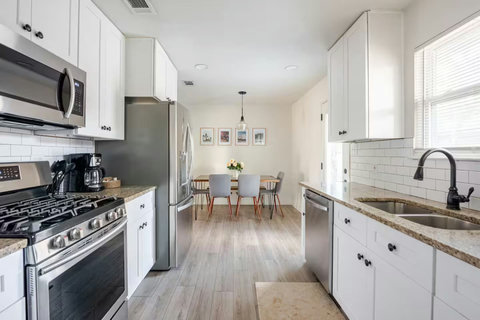 White kitchen with a gas range and granite counters