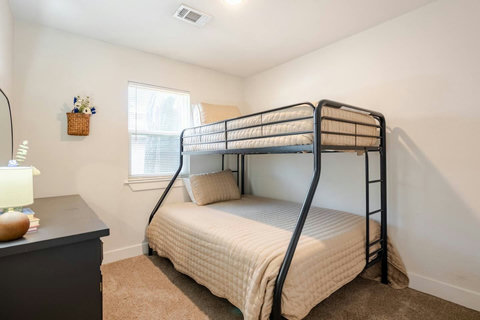 Bunk room with a lamp and dresser