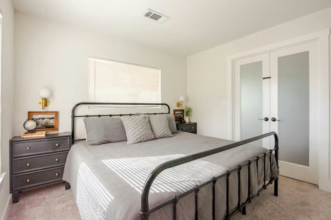 King bedroom with French doors and brass sconces