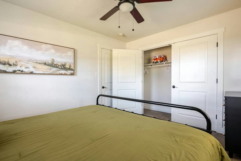 Bedroom with an olive comforter and closet
